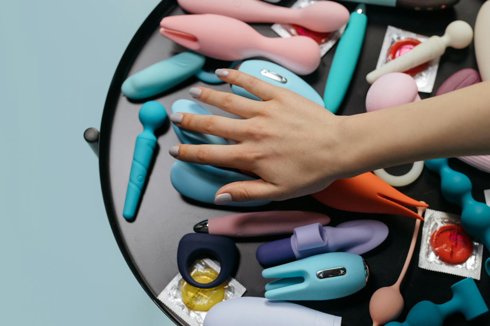 A sleek teal vibrator on white silk, symbolizing modern intimacy and pleasure adjustment