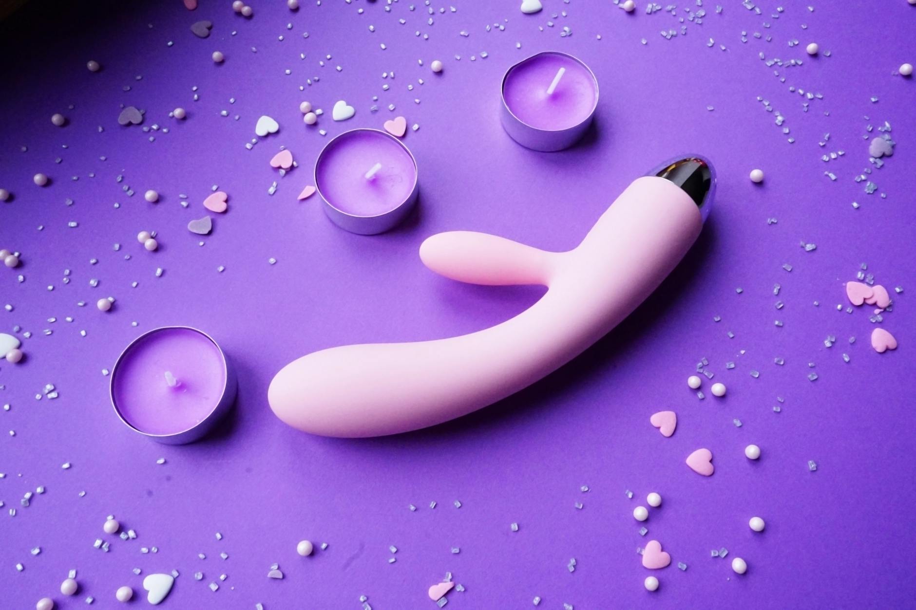 A blue silicone clitoral vibrator held gently in hand, representing sensitive pleasure exploration