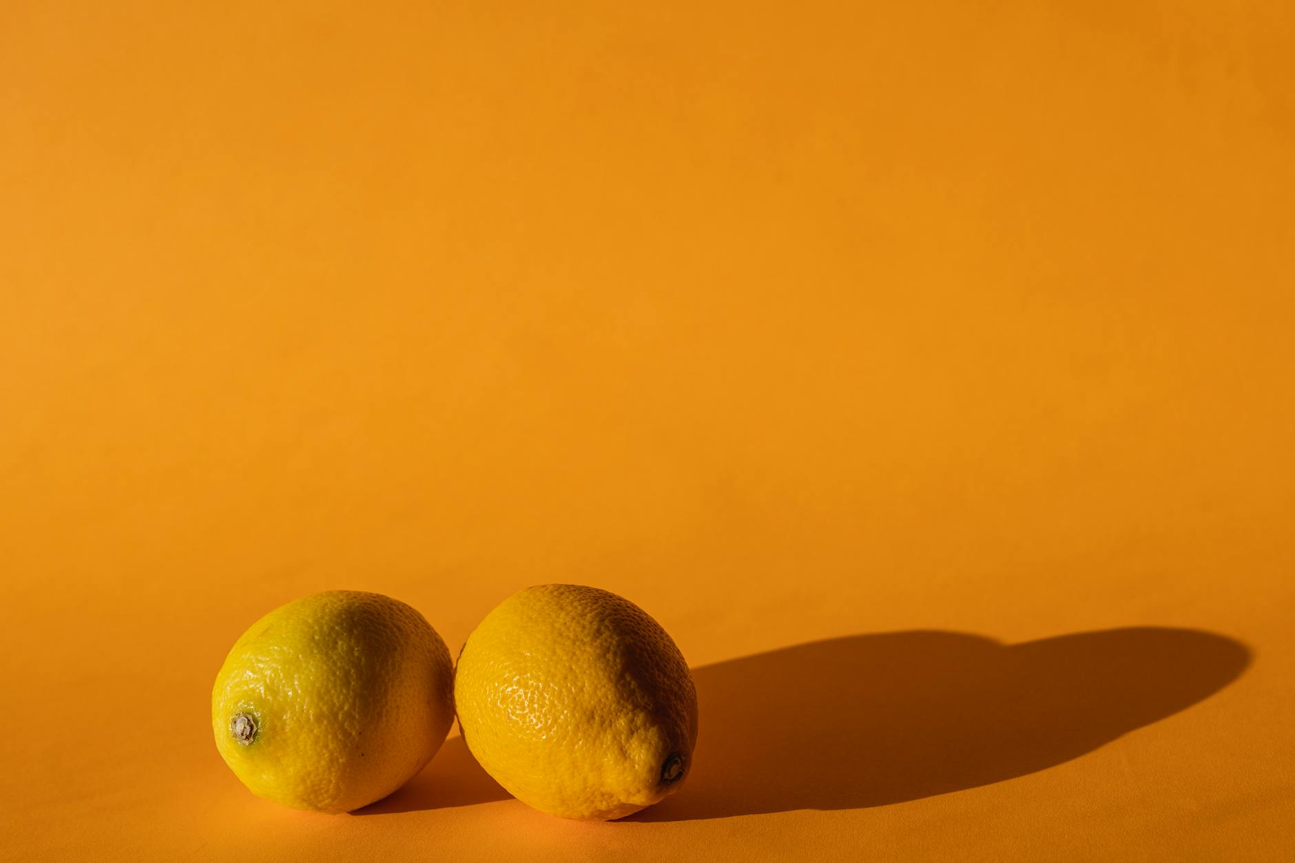Fresh vivid lemons on a bright yellow background, representing renewed sensation and vitality